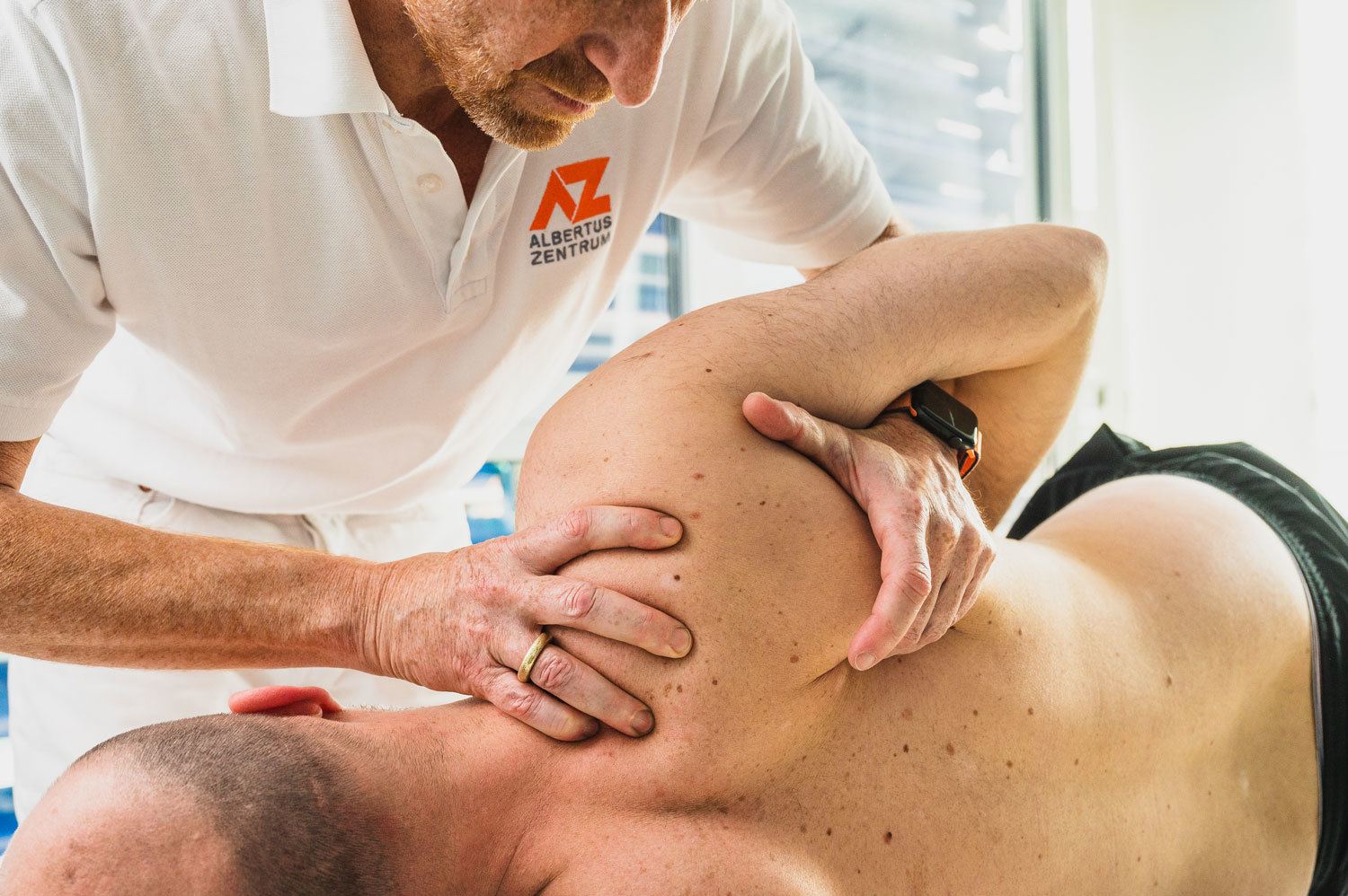 Orthopäde Alexej-Jian Zahedi untersucht einen Patienten im Rahmen der Osteopathie an der Schulter