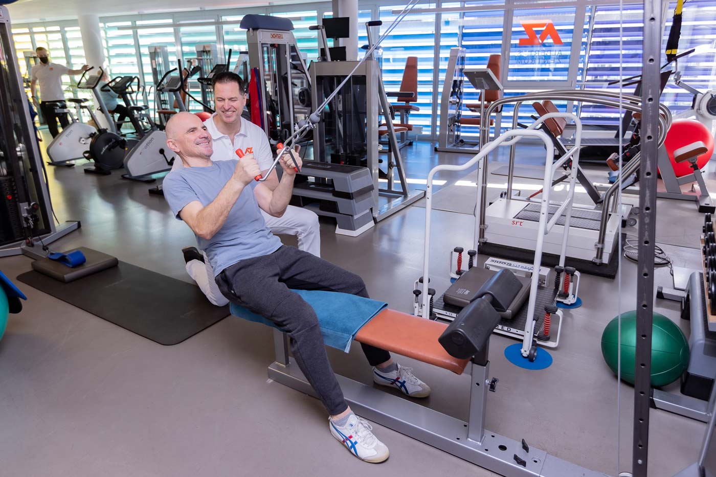 Patient trainiert auf der Trainingsfläche mit medizinischen Geräten für die Rückentherapie im Rückenzentrum Mönchengladbach