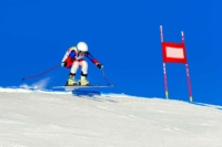 Eine Skifahrerin nimmt an einem Skiwettkampf teil, sie fährt die Piste herunter
