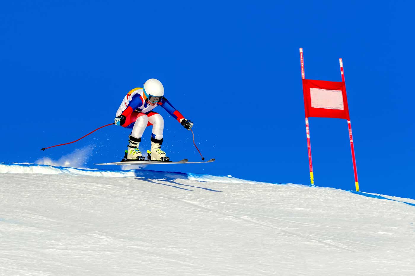 Eine Skifahrerin nimmt an einem Skiwettkampf teil, sie fährt die Piste herunter
